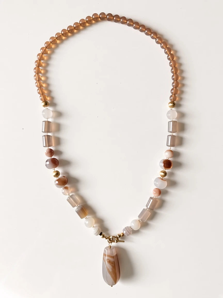 Hue La La Gems beaded statement necklace featuring natural taupe and cream agate beads with a teardrop pendant.