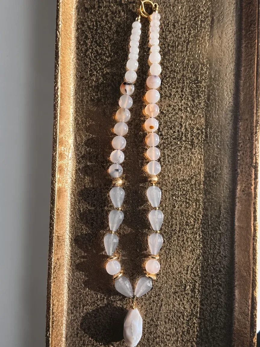 Hue La La Gems beaded necklace featuring blush, white, and grey agate beads with gold-tone spacers and a teardrop charm