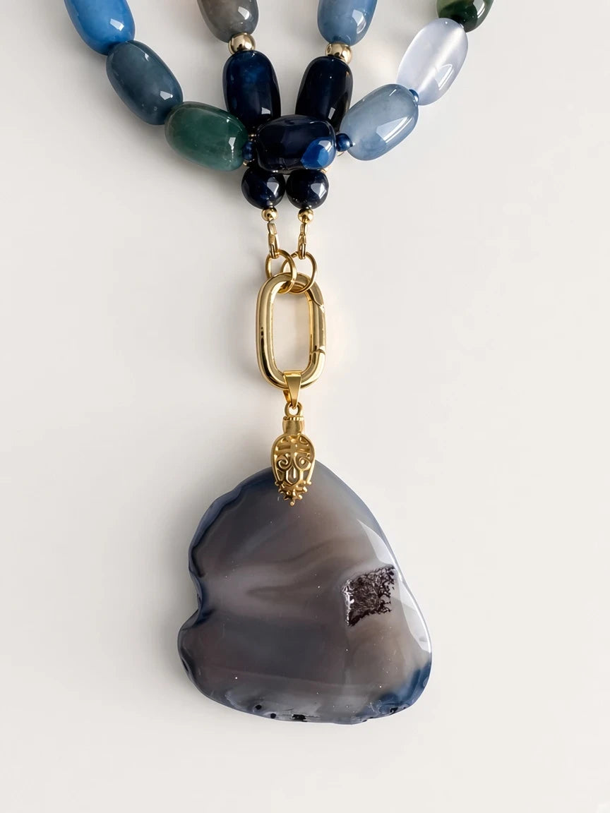 Hue La La Gems statement necklace featuring blue and grey agate beads with a large grey stone pendant and gold clasp.