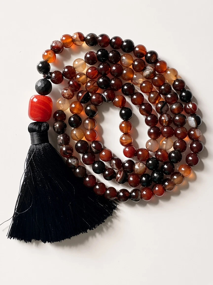 Hue La La Gems mala necklace with polished red and brown agate beads, a bright red accent bead, and a black silk tassel.