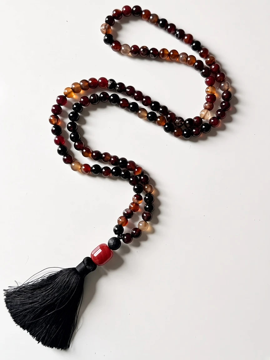 Hue La La Gems mala necklace with natural agate beads in red and brown, featuring a black silk tassel and red accent.