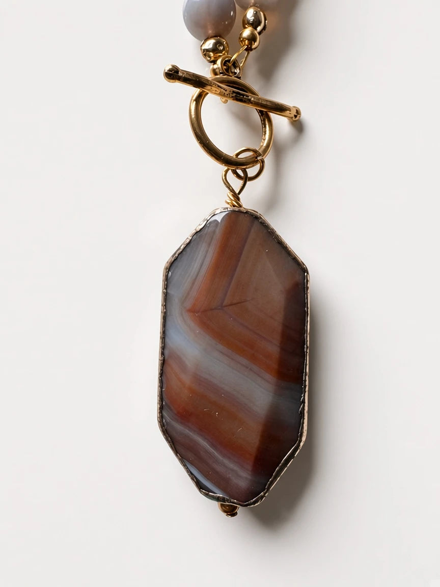 Hue La La Gems beaded necklace featuring a faceted brown and grey agate pendant with a gold-tone toggle clasp.
