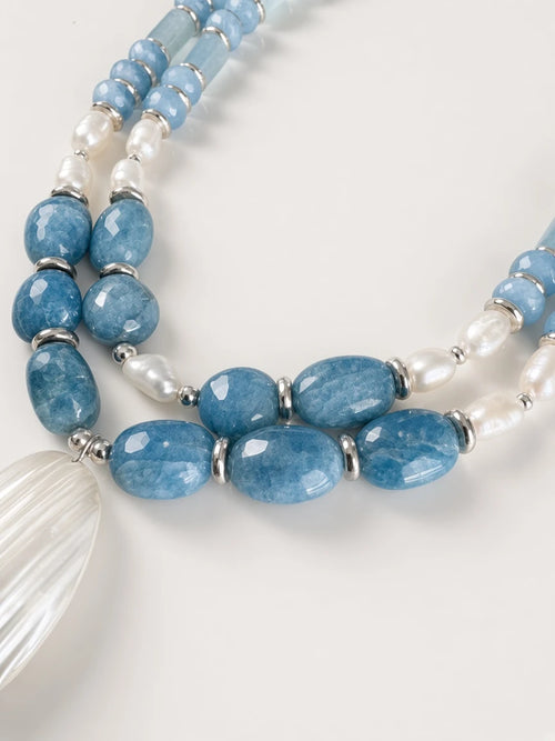 Hue La La Gems multi-strand statement necklace with blue aquamarine beads, freshwater pearls, and a shell pendant.