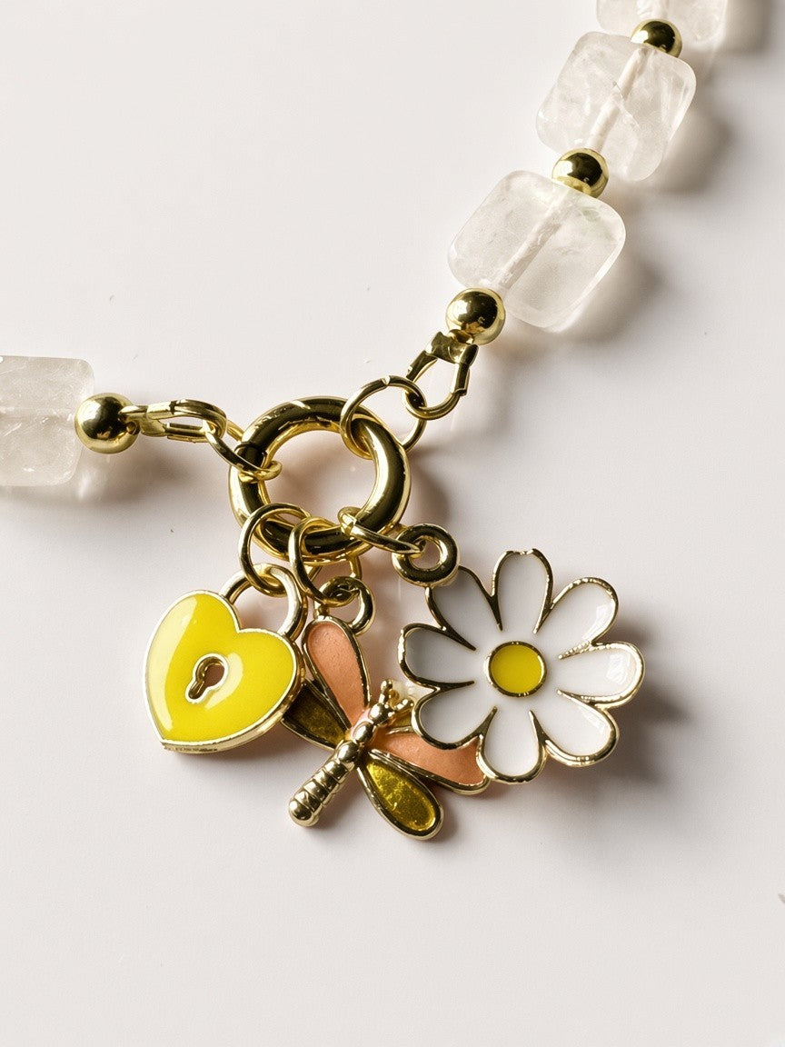 Hue La La Gems beaded necklace featuring a yellow heart lock, dragonfly, and daisy charm with gold-tone accents.