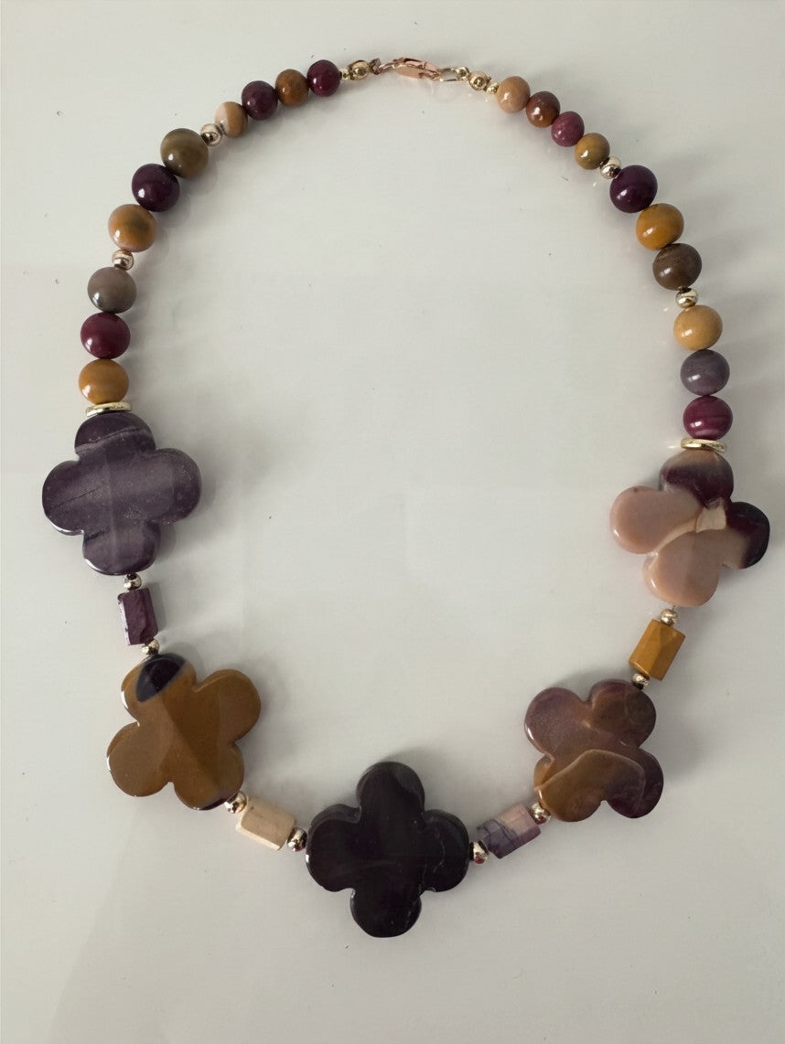 Hue La La Gems artisan statement necklace with multi-colored gemstone beads and gold-tone clover-shaped accents.