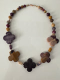 Hue La La Gems artisan statement necklace with multi-colored gemstone beads and gold-tone clover-shaped accents.