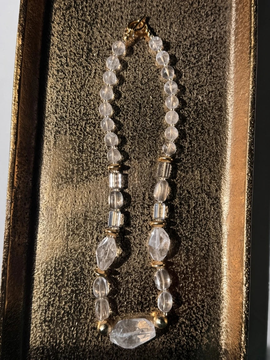 Hue La La Gems statement necklace featuring clear faceted crystal-like beads and polished gold-tone metal accents.