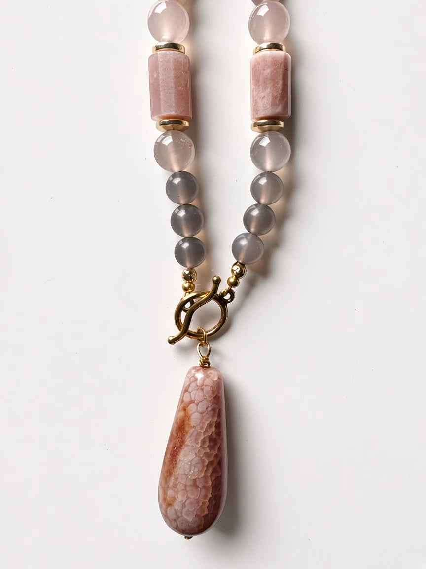Hue La La Gems beaded necklace with pink and grey agate stones, gold toggle clasp, and a textured gemstone pendant.