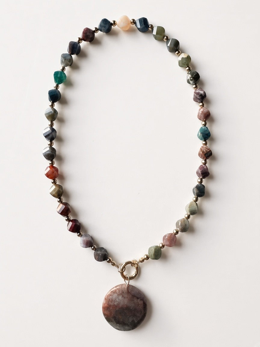Hue La La Gems beaded statement necklace featuring multi-colored faceted earth-toned gemstones and a circular pendant.