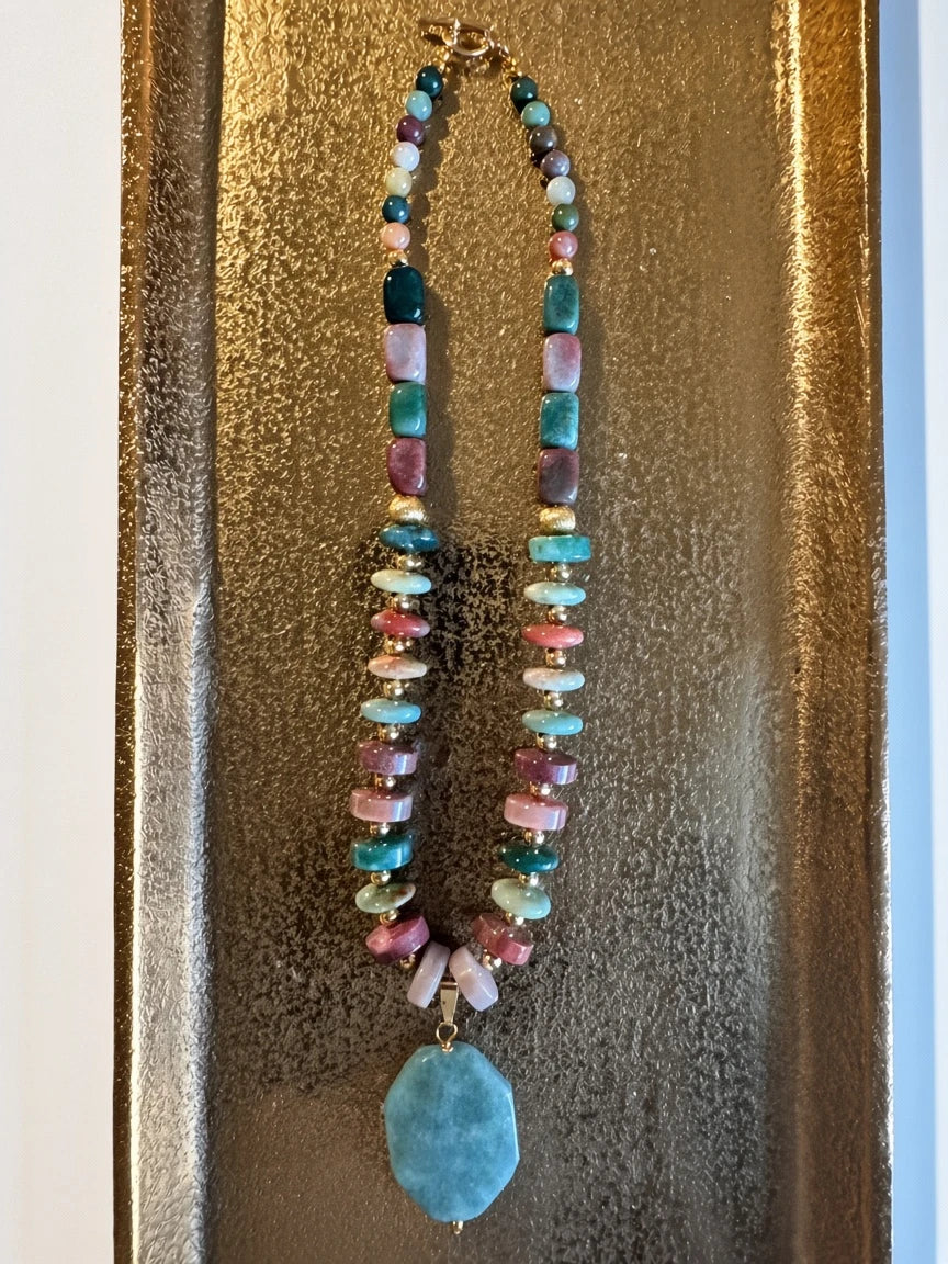 Hue La La Gems beaded statement necklace with multi-colored polished gemstones, gold-tone spacers, and green pendant.