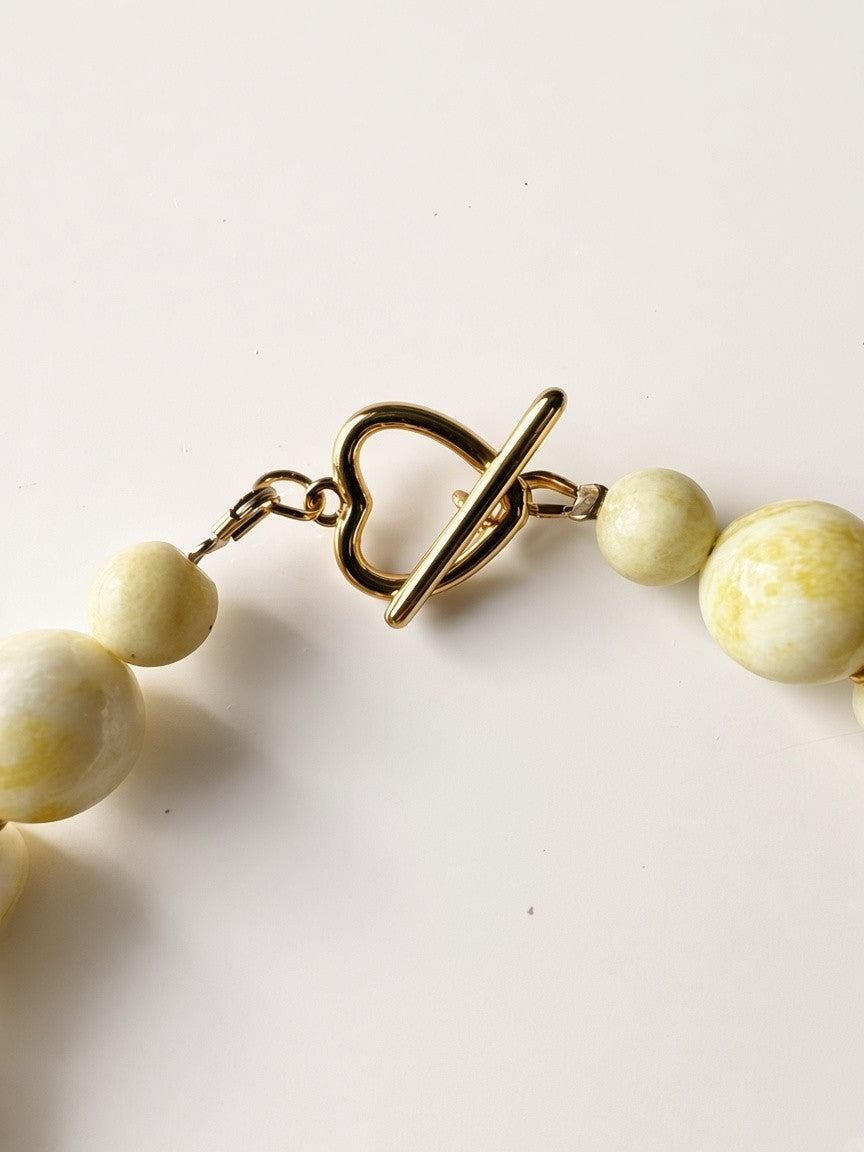 Hue La La Gems statement necklace featuring honey-toned gemstone beads and a gold-tone heart-shaped toggle clasp.