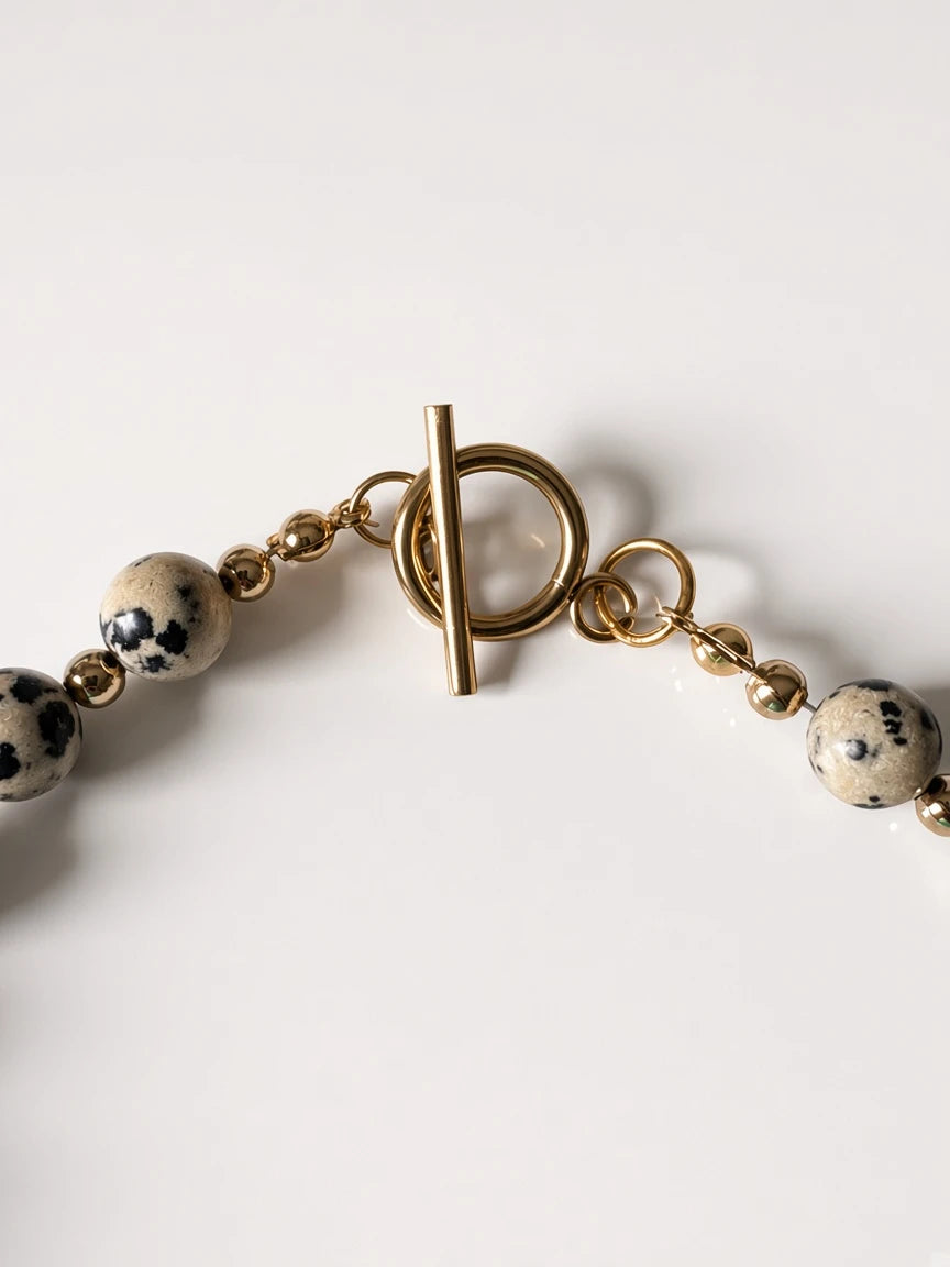 Hue La La Gems beaded necklace featuring dalmatian jasper beads, gold-tone spacers, and a polished toggle clasp.