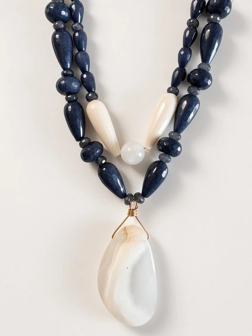 Hue La La Gems artisan beaded necklace set with navy and cream stone beads and a gold-wrapped organic stone pendant.