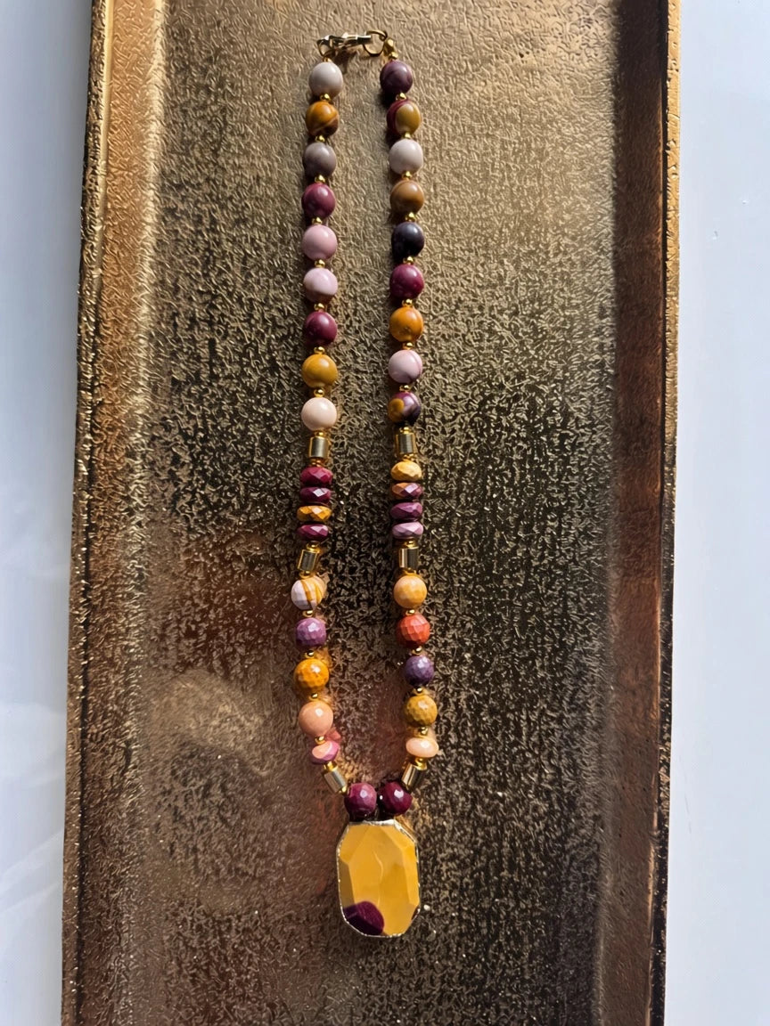 Hue La La Gems statement necklace with burgundy, mustard, and peach gemstone beads and a geometric yellow pendant.