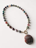 Hue La La Gems beaded statement necklace with multi-colored faceted earth-toned stones and a large circular pendant.