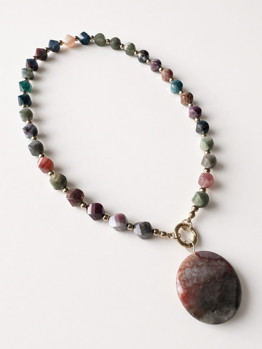 Hue La La Gems beaded statement necklace with multi-colored faceted earth-toned stones and a large circular pendant.