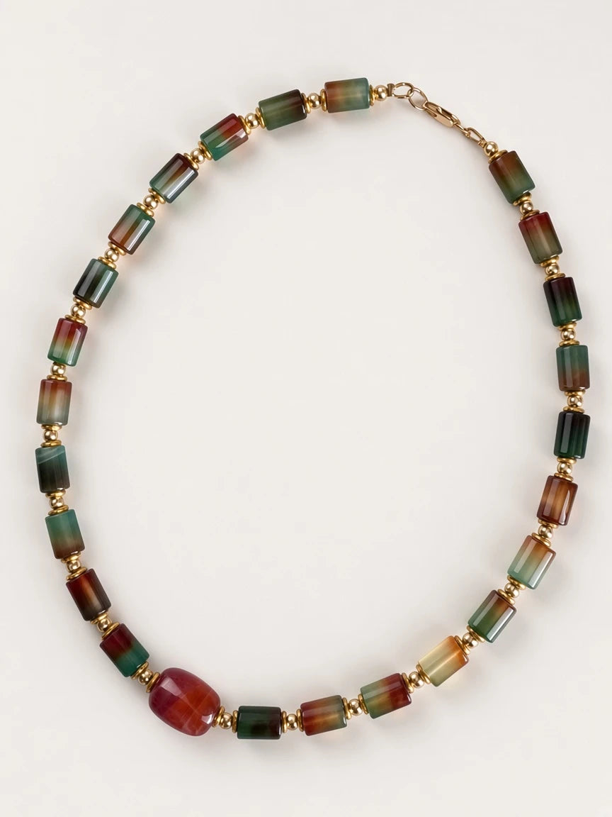 Hue La La Gems statement necklace featuring cylindrical multi-colored gemstone beads and polished gold-tone spacers.