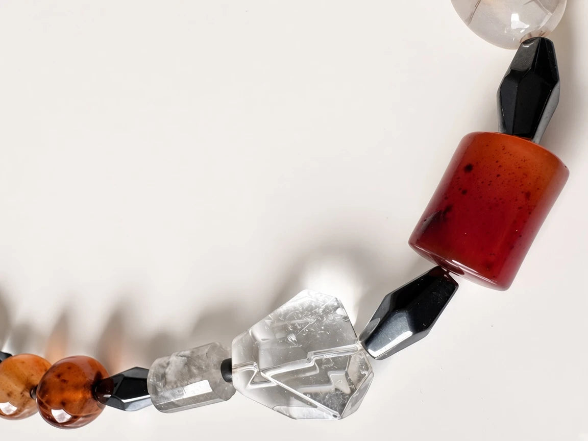 Hue La La Gems artisan statement necklace featuring carnelian, clear quartz, and obsidian beads on a white background.