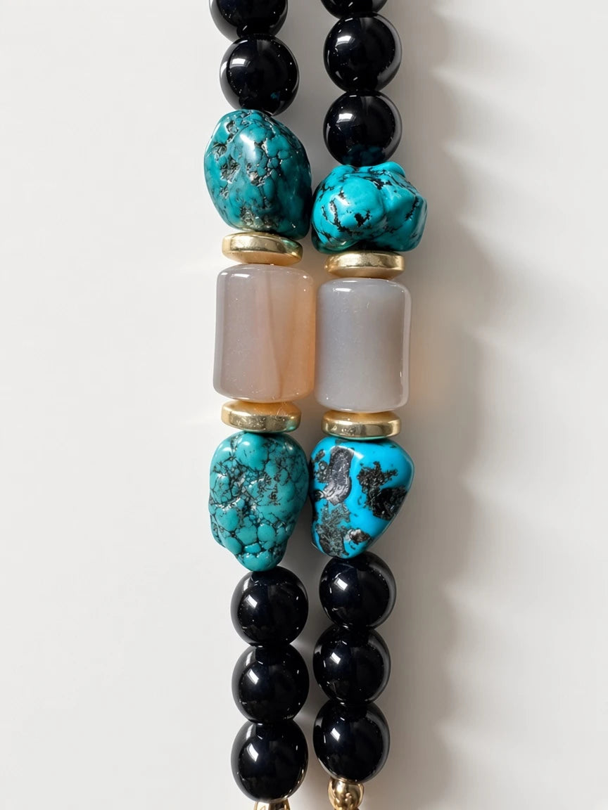 Hue La La Gems beaded necklace featuring black beads, turquoise, and smooth beige stones with gold-tone accents.