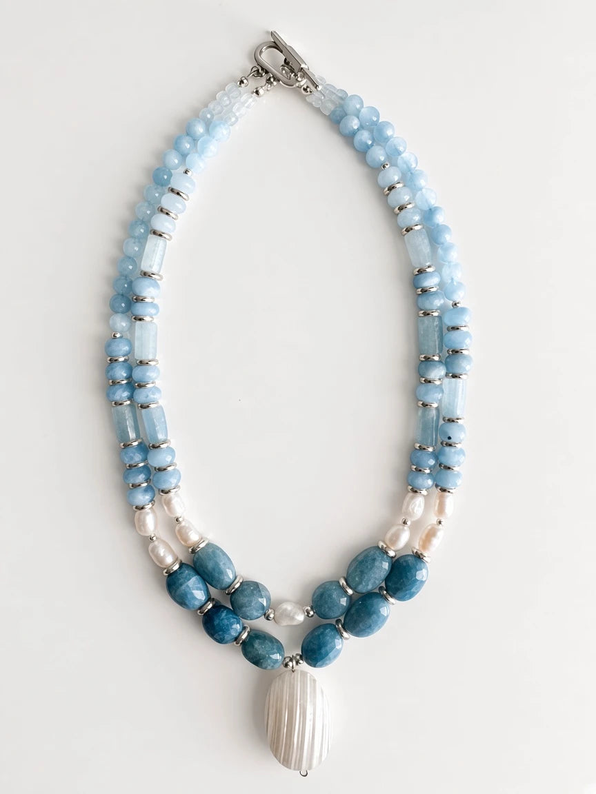 Hue La La Gems multi-strand statement necklace with blue aquamarine beads, freshwater pearls, and a shell pendant.