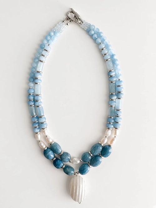 Hue La La Gems multi-strand statement necklace with blue aquamarine beads, freshwater pearls, and a shell pendant.