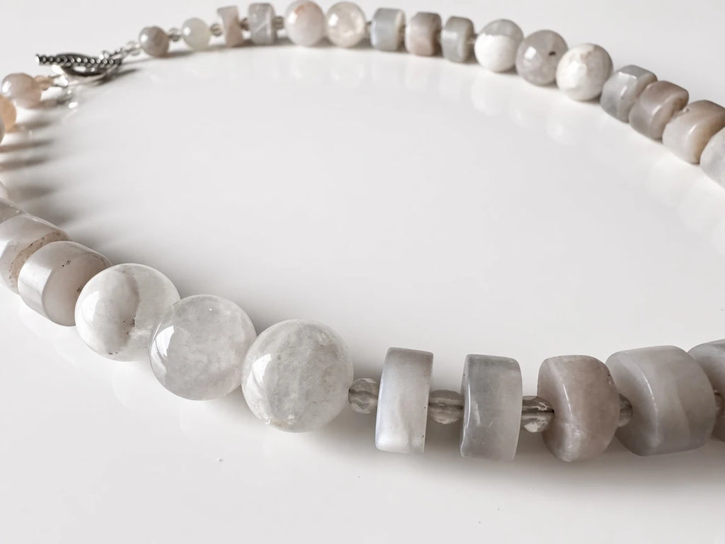 Hue La La Gems handcrafted statement necklace with faceted moonstone-style beads and neutral fossilized coral accents.