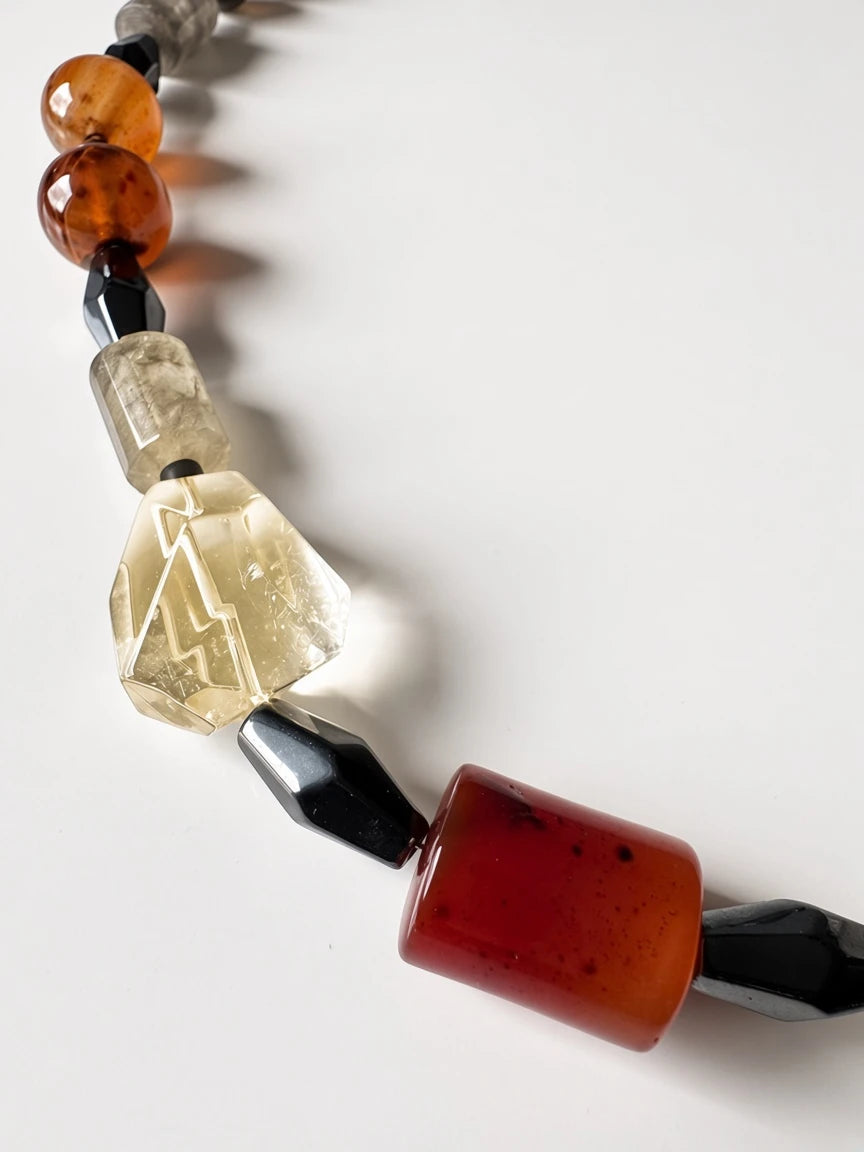 Hue La La Gems artisan statement necklace with carnelian, clear quartz, and obsidian beads on a white background