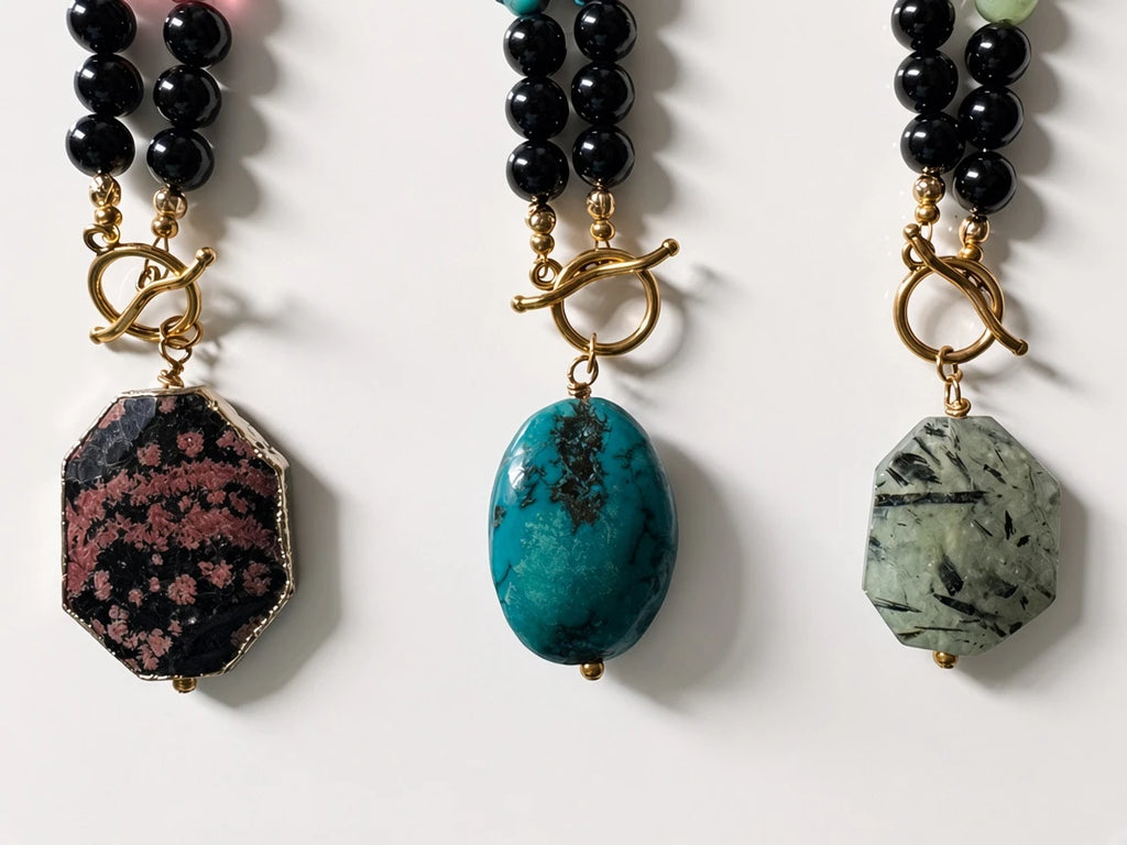 Hue La La Gems beaded statement necklaces featuring black beads, gold toggle clasps, and unique semi-precious pendants.