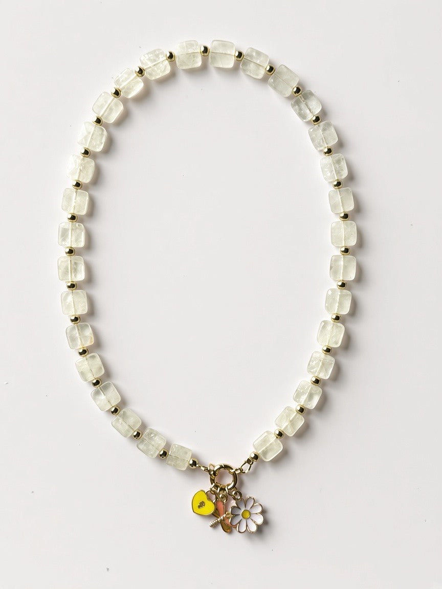 Hue La La Gems beaded necklace with translucent square stones, gold spacers, and yellow heart and daisy charms.