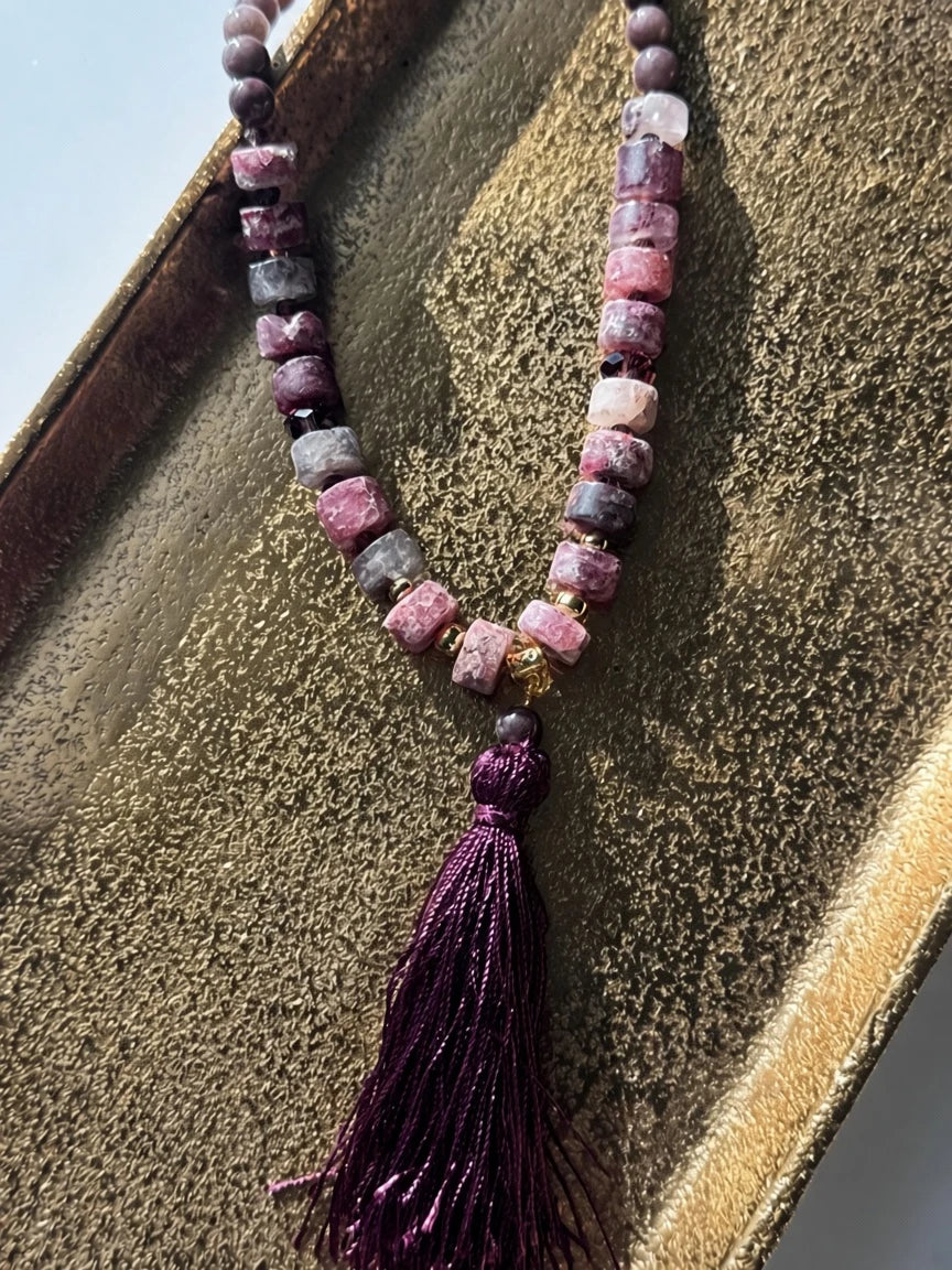 Hue La La Gems statement necklace with plum, mauve, and dusty rose stone beads, gold accents, and a purple silk tassel.