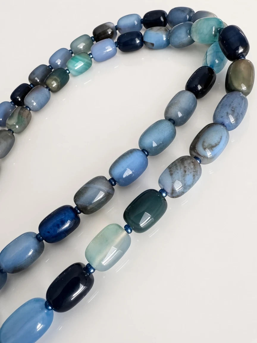 Hue La La Gems blue agate beaded necklace featuring polished oval beads in varying shades of navy, teal, and sky blue.