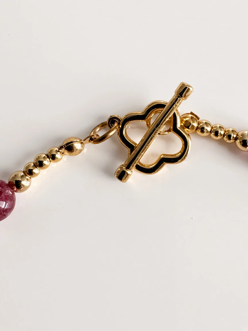 Hue La La Gems beaded necklace featuring a gold-tone clover-inspired toggle clasp and pink gemstone beads.