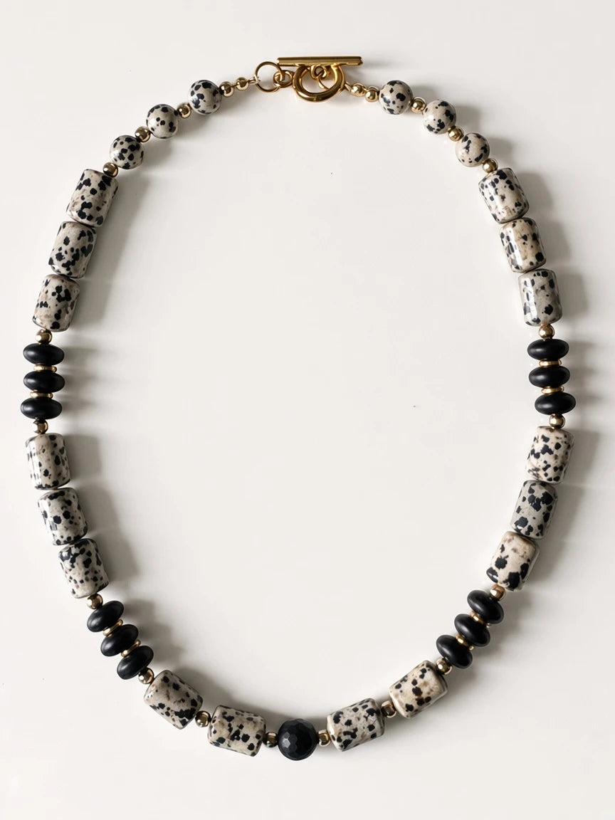 Hue La La Gems statement necklace featuring dalmatian jasper and matte black beads with gold-tone spacers and toggle
