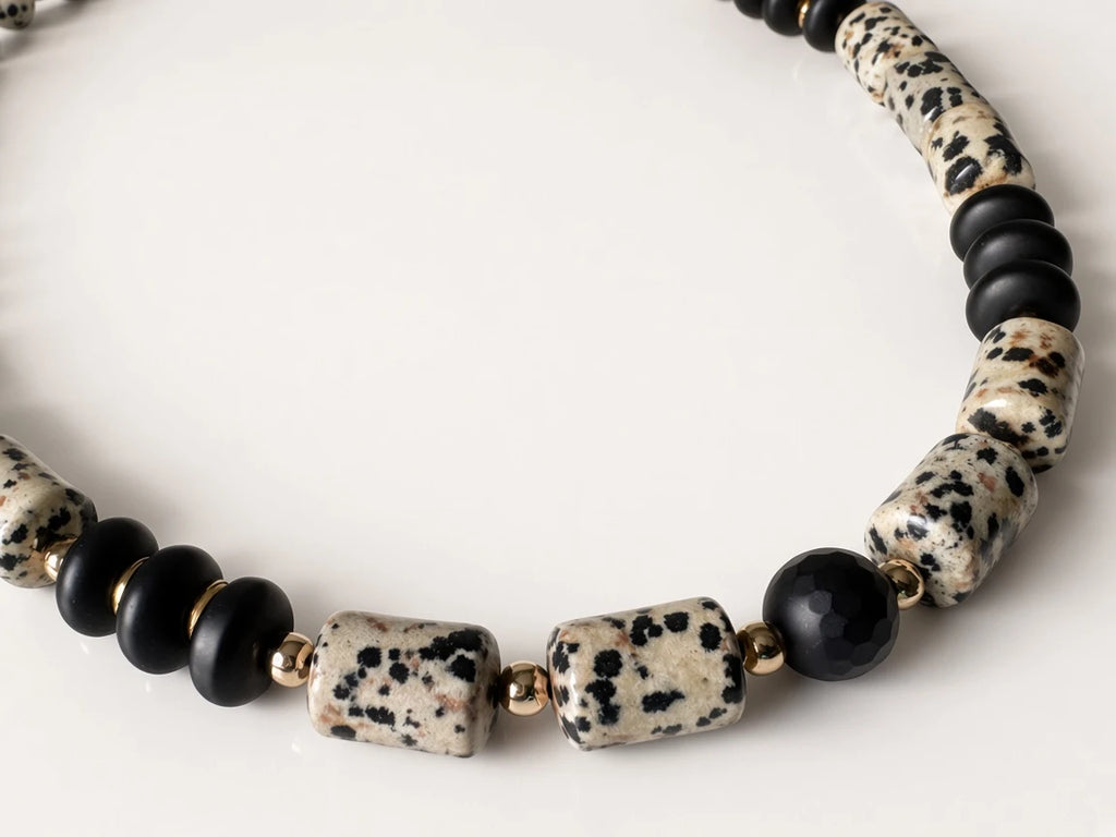 Hue La La Gems statement necklace featuring dalmatian jasper beads, matte black beads, and polished gold-tone spacers.