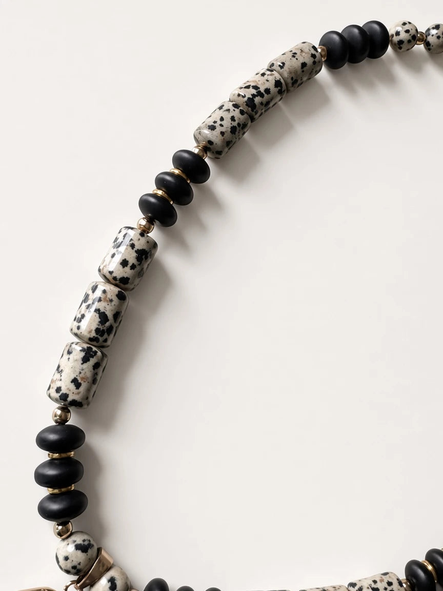 Hue La La Gems statement necklace featuring dalmatian jasper beads, matte black beads, and polished gold-tone spacers.