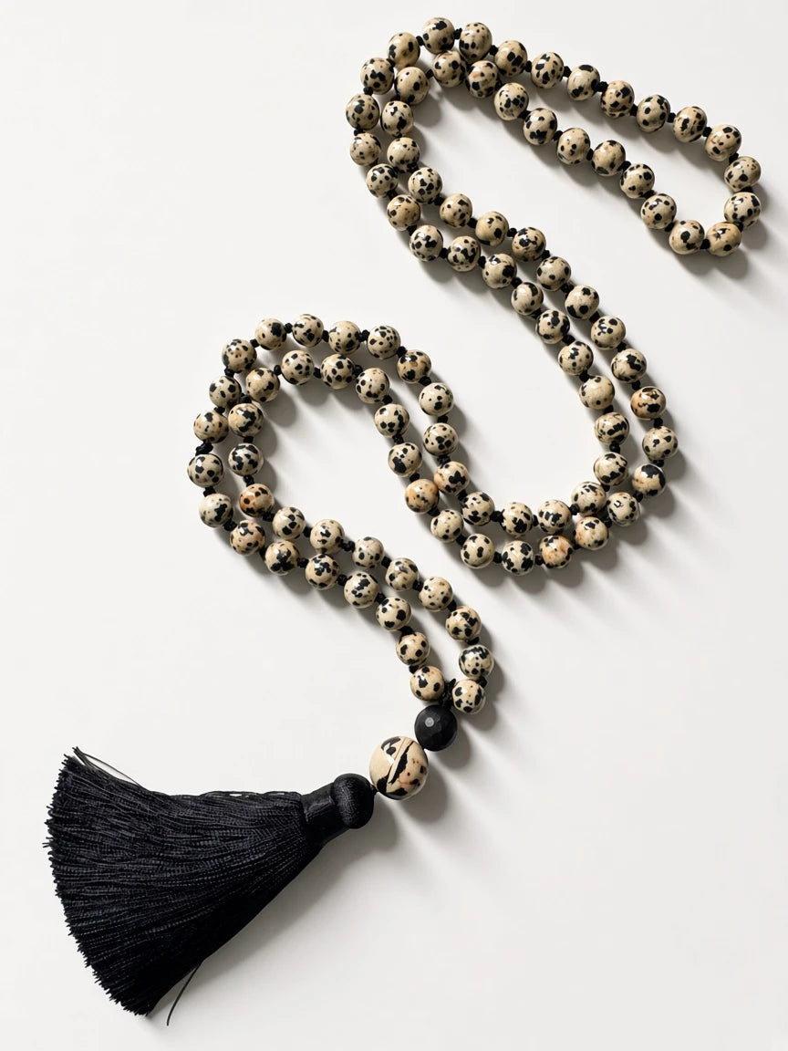 Hue La La Gems Dalmatian Jasper mala necklace with 108 hand-knotted beads and a black silk tassel on white background