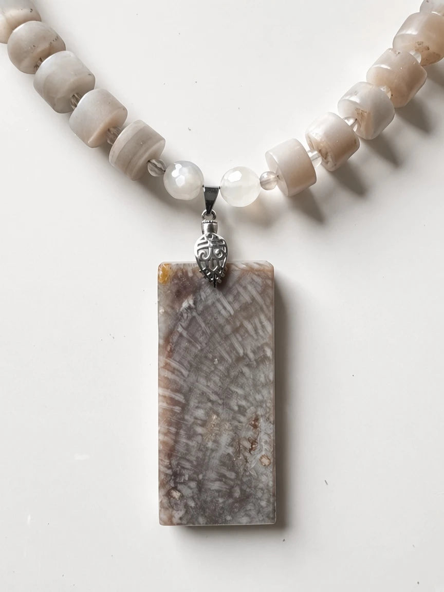 Hue La La Gems handcrafted statement necklace with a rectangular fossilized coral pendant and neutral stone beads.