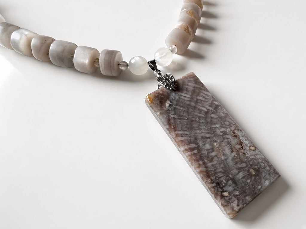 Hue La La Gems handcrafted statement necklace with a rectangular fossilized coral pendant and neutral stone beads.