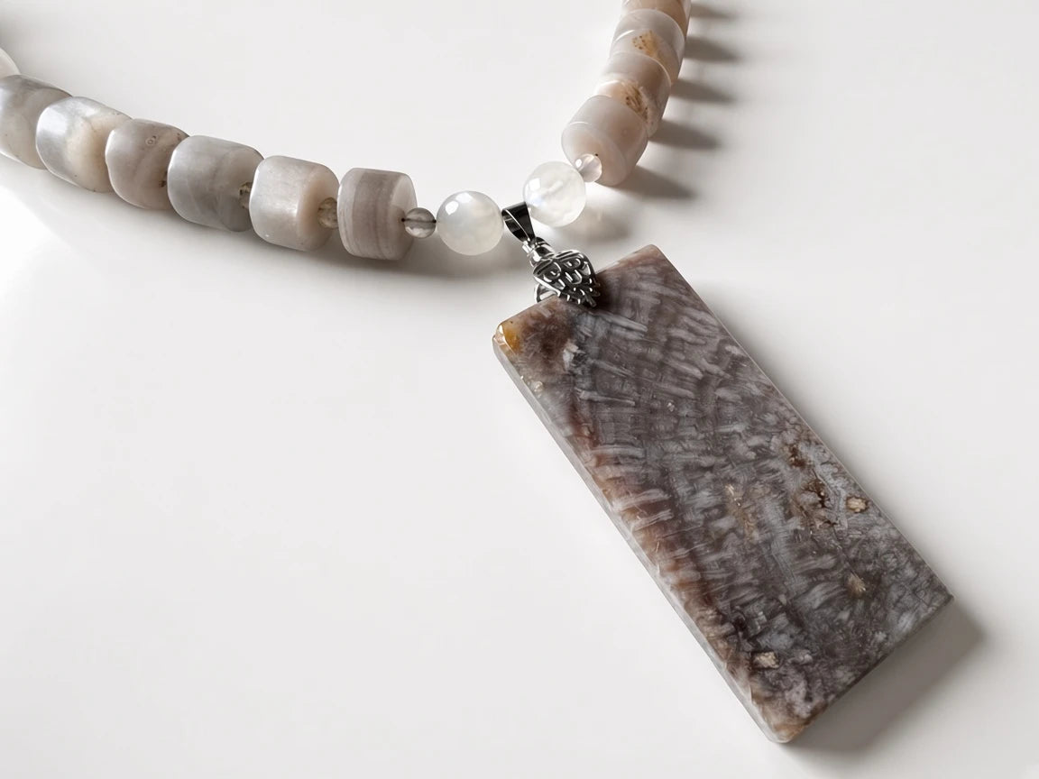 Hue La La Gems handcrafted statement necklace with a rectangular fossilized coral pendant and neutral stone beads.