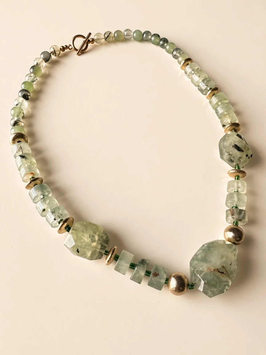 Hue La La Gems beaded statement necklace featuring pale green gemstone beads, faceted shapes, and gold-tone accents.