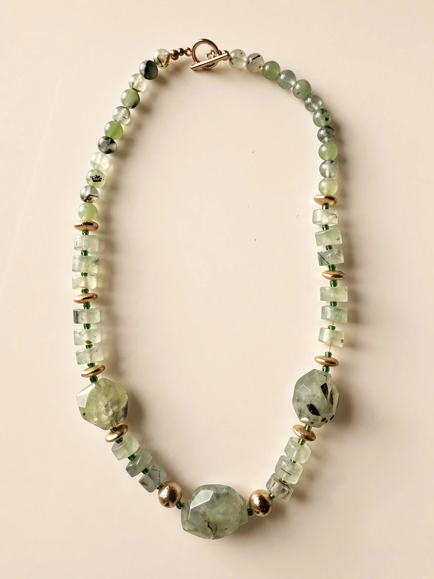 Hue La La Gems beaded statement necklace with pale green gemstone beads, faceted shapes, and gold-tone metal accents.