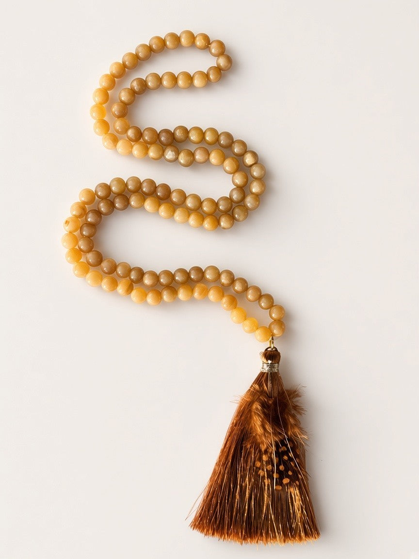 Hue La La Gems honey-toned gemstone beaded necklace with a brown feather tassel on a white background