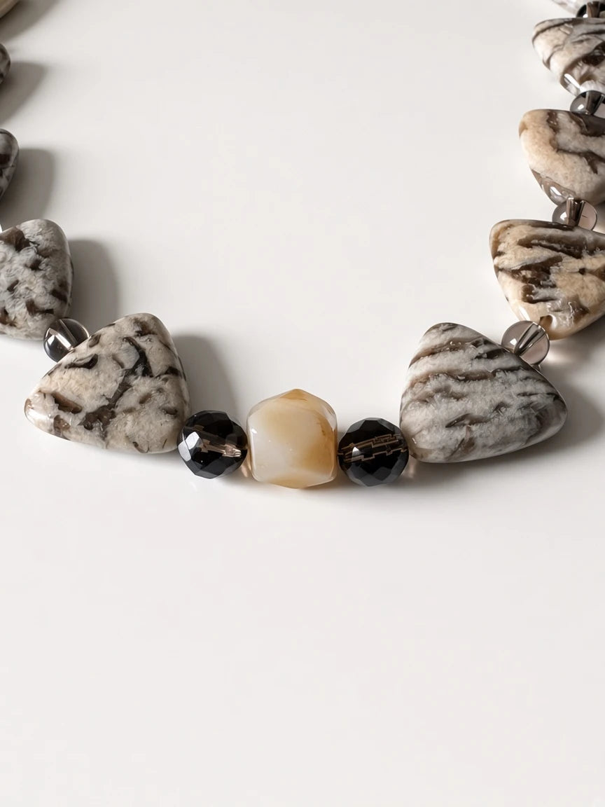 Hue La La Gems artisan statement necklace with patterned jasper-style triangular beads and smoky stone accents.