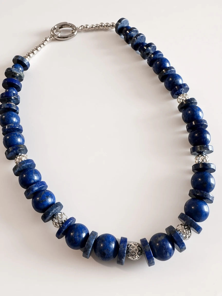Hue La La Gems lapis lazuli beaded statement necklace with alternating blue stone shapes and silver-toned metal beads.