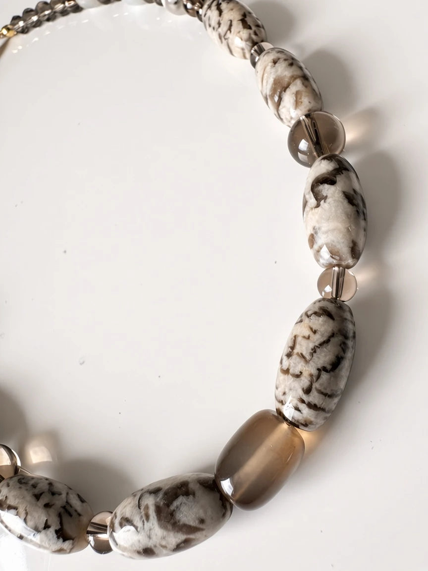 Hue La La Gems statement necklace featuring marbled stone and translucent smoky quartz-style beads in earthy tones.