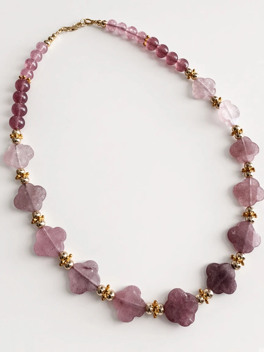 Hue La La Gems beaded statement necklace featuring mauve floral gemstone beads and polished gold-tone metal accents.