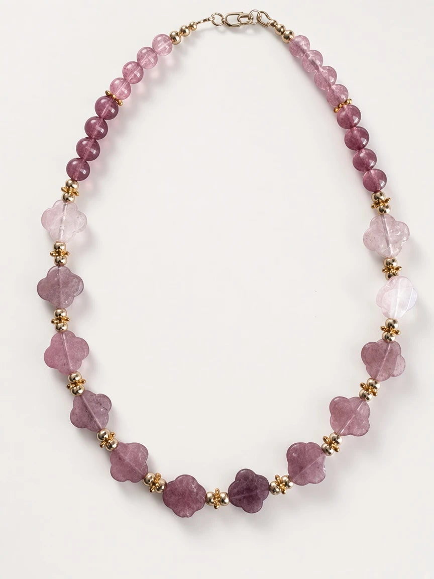 Hue La La Gems beaded statement necklace with mauve floral gemstone beads and gold-tone accents on a white background.