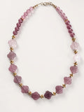 Hue La La Gems beaded statement necklace with mauve floral gemstone beads and gold-tone accents on a white background.
