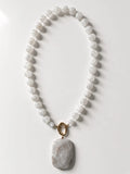 Hue La La Gems beaded statement necklace featuring iridescent moonstone beads and a large rectangular marble pendant.