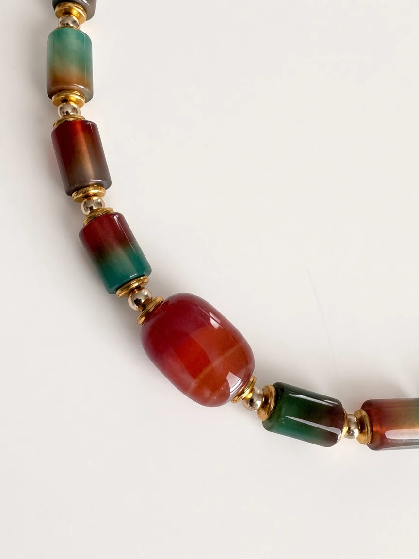 Hue La La Gems statement necklace featuring multi-colored cylindrical gemstone beads with gold-tone spacers.